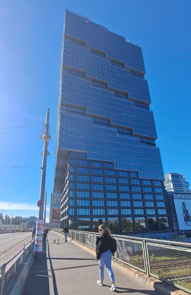 Gathering im KiezLab Berlin Gebäude mit blauer Glasfassade bei Sonnenschein